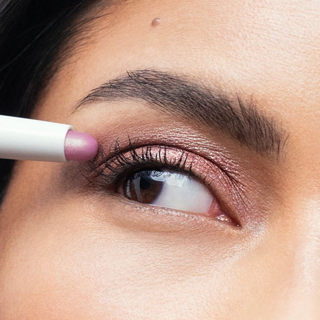 Close up of model eye showcasing defined brows and a natural, shimmery eye look